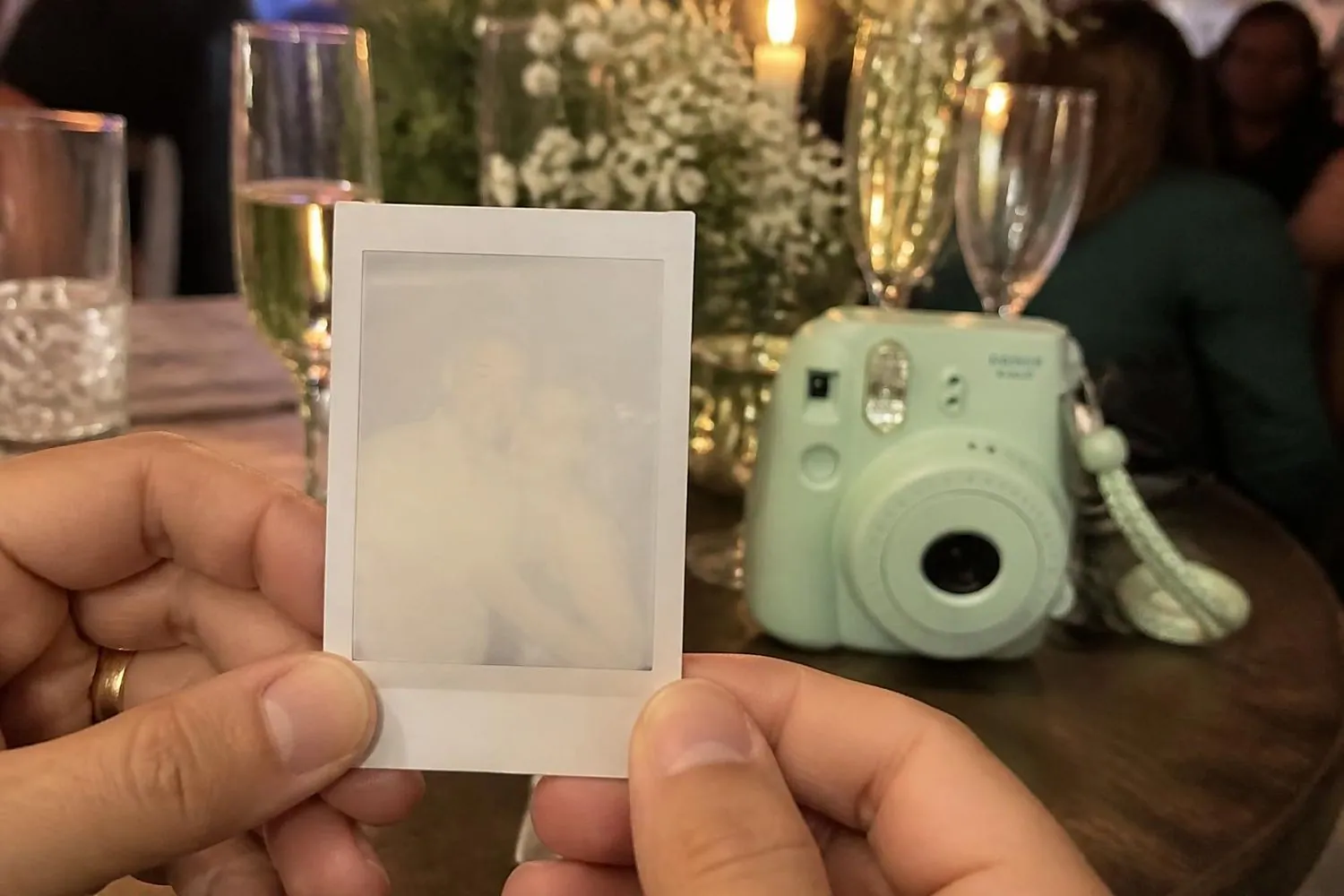 Ilustração: convidada segurando uma foto instantânea que ainda está revelando